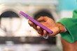 © Alba Vitta/Stocksy - Hand holding smartphone at laundry