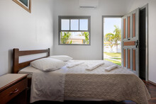 Hotel Bedroom With Window And Door Open Showing Green Garden Palm Tree