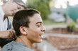 © ByLorena/Stocksy - Mom shaving her teenage son outdoors