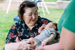 © Maria Manco/Stocksy - Great grandmother holds newborn baby