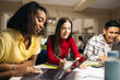 © Pedro Merino/Stocksy - Students doing work and studying with laptops and notes in the college