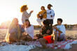 © BONNINSTUDIO/Stocksy - Group of friends spending time on beach at sunset