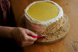 © Duet Postscriptum/Stocksy - An adult woman's hand decorates a homemade lemon curd cake