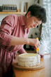 © Duet Postscriptum/Stocksy - An adult woman prepares a cake for a party
