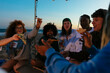 © BONNINSTUDIO/Stocksy - Group of diverse friends having fun together at sunset