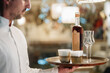 © Daniel Gonzalez/Stocksy - Crop waiter serving drinks in restaurant