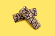 © halcon1 - Two bars of whole oatmeal and chocolate on a yellow isolated background. Delicious healthy snack or energy replenishment. Whole grain energy bars with chocolate