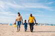 © Ezequiel Giménez/Stocksy - Happy black family strolling on beach