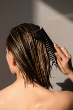 Combing wet hair with applied mask on them 