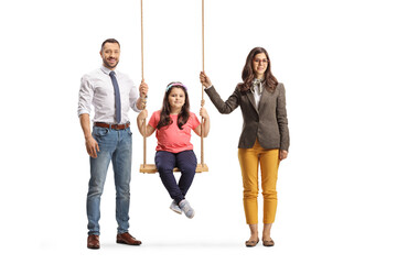 Wall Mural - Girl sitting on a swing and her parents standing by her side