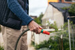 © Pedro Merino/Stocksy - Unrecognizable senior man watering plants in an urban garden