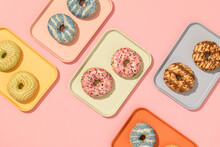 Pastel Color Donuts With Colorful Trays On Pink Background