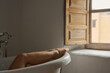© Guille Faingold/Stocksy - Relaxed female legs in bathtub.