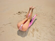 © Iryna Shepetko/Stocksy - Woman in pink On Summer Beach Vacation raised legs