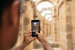 © Pedro Merino/Stocksy - Man taking photos with smartphone in El Djem amphitheater