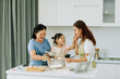 © Marc Tran/Stocksy - Happy asian three generation family baking together in kitchen