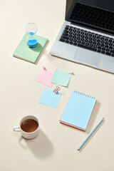 note book and laptop on beige table with coffee