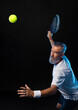 Old padel tennis player with racket in action. Man athlete with paddle tenis racket on court with neon colors. Sport concept. Download a high quality photo for the design of a sports app.