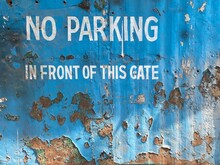 No Parking In Front Of This Gate Is Written On A Metallic Surface