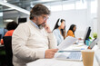 © Santi Nuñez/Stocksy - Senior man using laptop in office