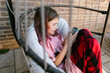 © Maria Manco/Stocksy - Tween girl sits on swing chair and texts on her phone
