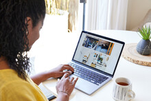 Black Woman Looking At Photos Of Vacation Rental On Computer At Home