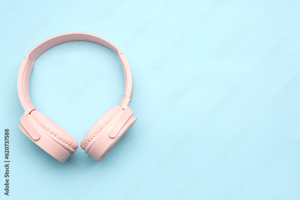 Modern pink headphones on blue background
