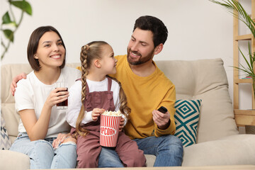 Canvas Print - Happy family watching TV with popcorn on sofa indoors, space for text