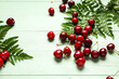 © Pixel-Shot - Many sweet cherries and leaves on green wooden background