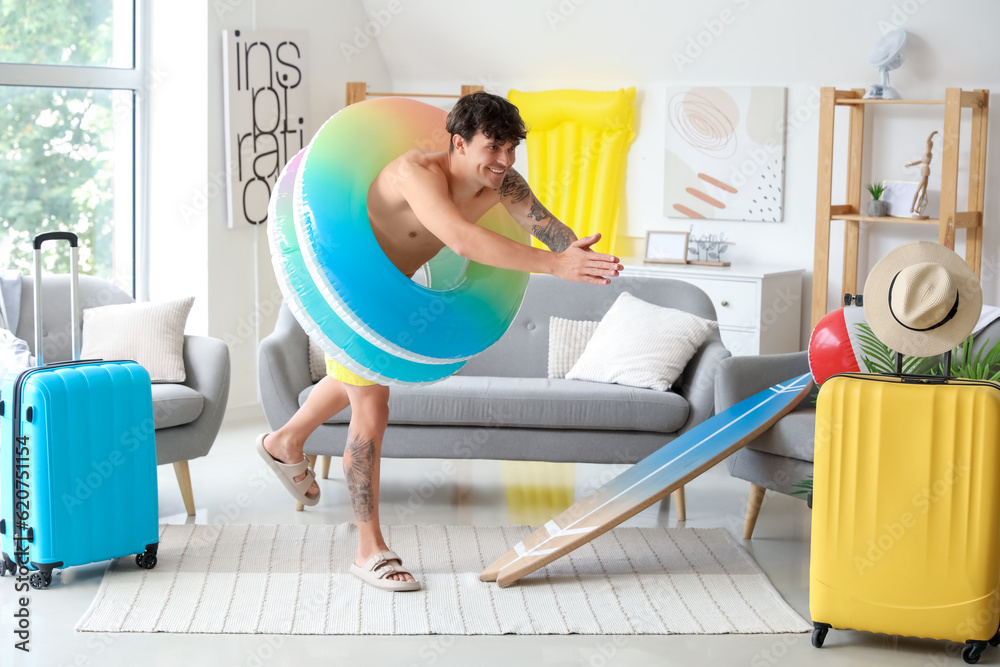 Young man with swim rings ready for summer vacation at home