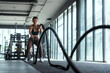 © 2B - Woman with battle rope battle ropes exercise in the fitness gym. gym, sport, rope, training, athlete, workout, exercises concept