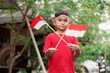 happy indonesian kid with flag at outdoor