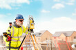 © Iryna - Surveyor builder site engineer with theodolite total station at construction site outdoors during surveying work