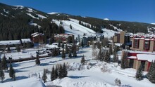 Drone Aerial Copper Mountain Winter Ski Snowboard Resort Ikon Pass Parking Lot Lodging Hotels Colorado Early Morning Sunlight Fresh Snow Ski Lift Crowd Cinematic Forward Pan Up Motion 4k