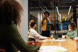 © wavebreak3 - African american casual businesswoman using tablet and making notes on glass wall in meeting room