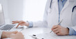 © rogerphoto - Doctor and patient discussing something and using laptop while sitting opposite each other at the desk in clinic office. Perfect medical service and medicine concept