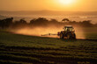 © ADDICTIVE STOCK - Generative AI image of heavy tractor spraying pesticides on agriculture field with green plantation rows during sunset