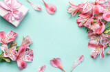 Fototapeta Tulipany - Beautiful Alstroemeria flowers and gift boxes on light green background