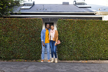 Portrait Of African American Young Couple Standing By Green Ivy Wall Outside House