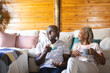 © Wavebreak Media - Happy senior african american couple sitting on floor and drinking coffee at home