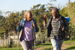 © Wavebreak Media - Happy senior african american couple with backpacks walking in sunny nature