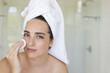 © Wavebreak Media - Portrait of caucasian woman with towel on head using pad on face in bathroom, copy space