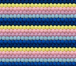 Geometric volumetric seamless knitted pattern in the form of bumps. The texture is crocheted from multi-colored yarn. Pastel contrasting color combination.