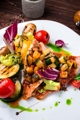 Canvas Print - Pieces of pork fillet with grilled vegetables champignons, zucchini, tomatoes, red pepper and spices, closeup.