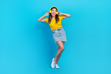 Wall Mural - Full body photo of crazy positive lady hands touch headphones have good mood isolated on blue color background