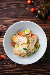 Wall Mural - Caesar salad with chicken, parmesan cheese, eggs, lettuce, tomatoes and croutons, Italian food.