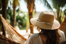A Glimpse Of A Young Stylish Woman's Back, As She Relaxes In A Hammock Strung Between Palm Trees, Her Straw Hat Providing A Sense Of Relaxation Generative AI