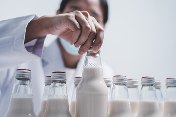 Quality control laboratory dairy factory professional people checking milk bottles quality, Dairy factory industry products.