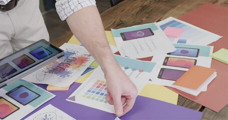 Wall Mural - midsection of caucasian male creative using tablet and looking at design work, slow motion