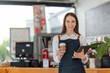 © Natee Meepian - Startup successful small business owner sme beauty girl stand with tablet in coffee shop restaurant. Portrait of asian woman barista cafe owner. SME entrepreneur seller business concept